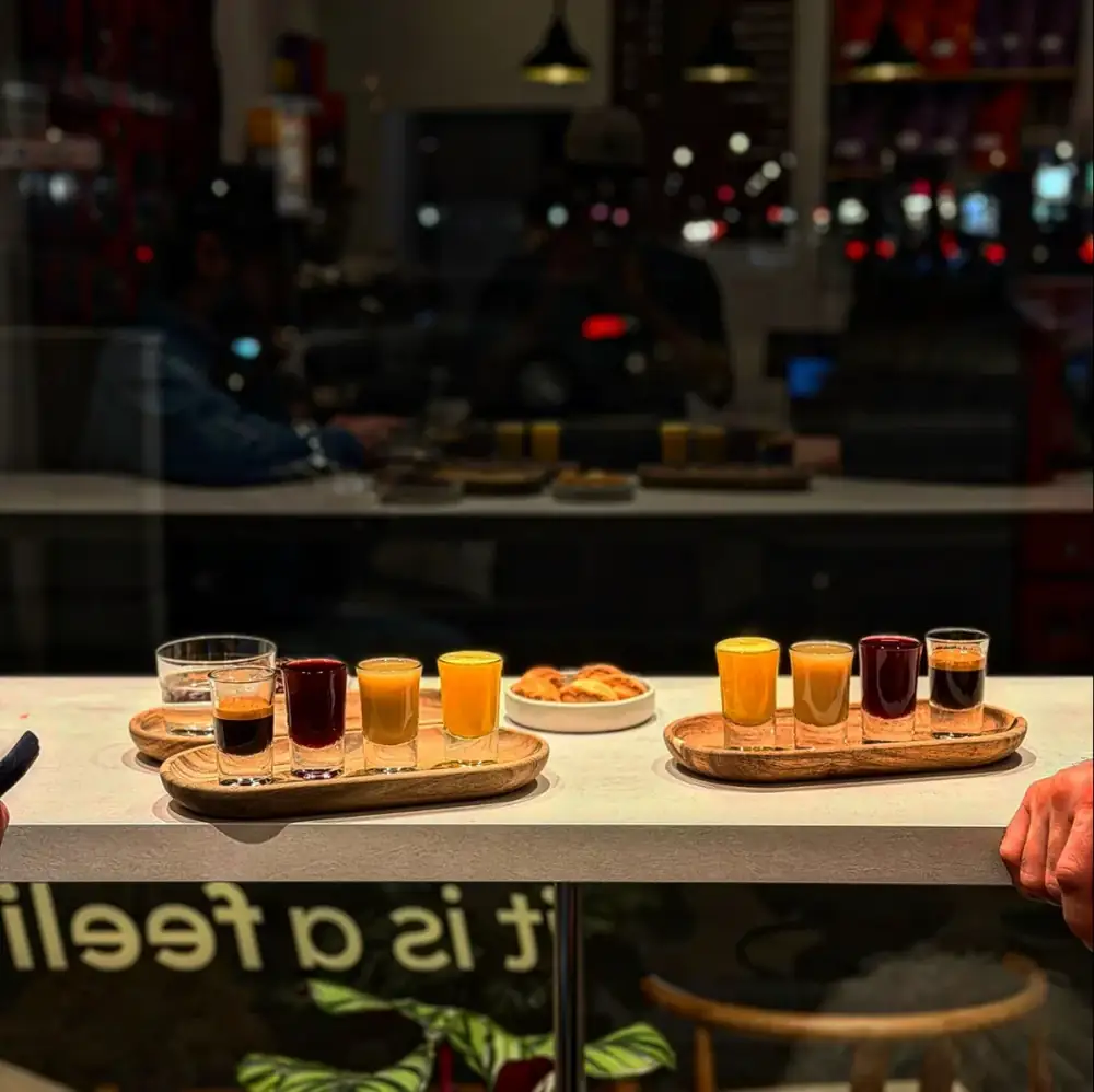 Holzbretter mit je vier kleinen Gläsern: Espresso und bunte Shots